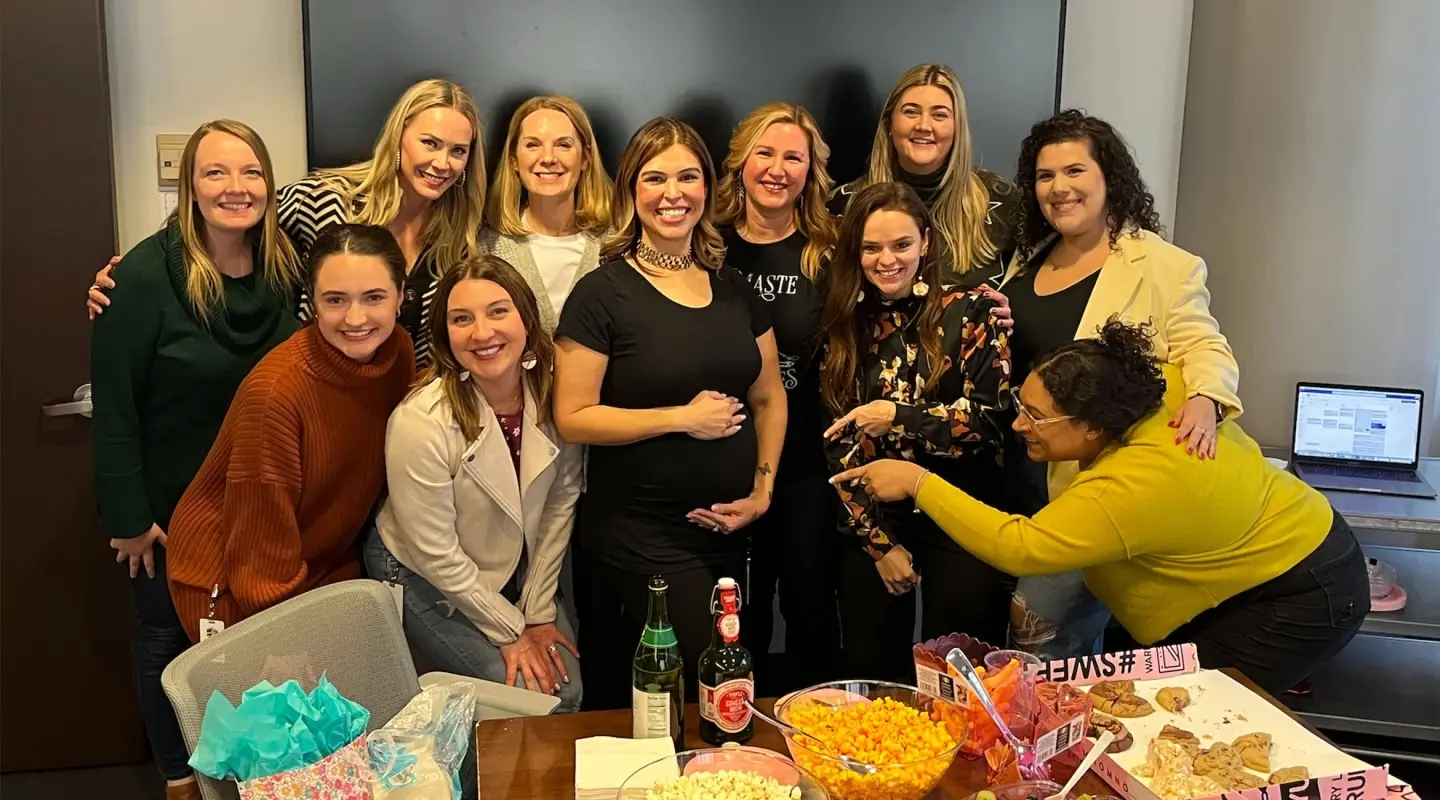 Pregnant Salazar posing with co-workers for work baby shower