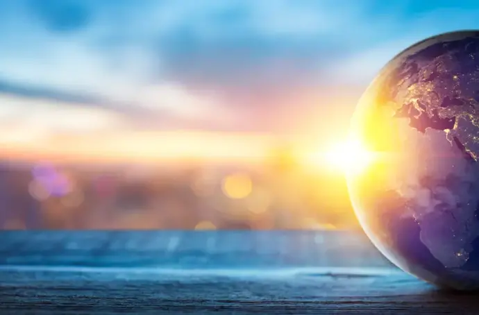 Globe on wood surface with sunset behind