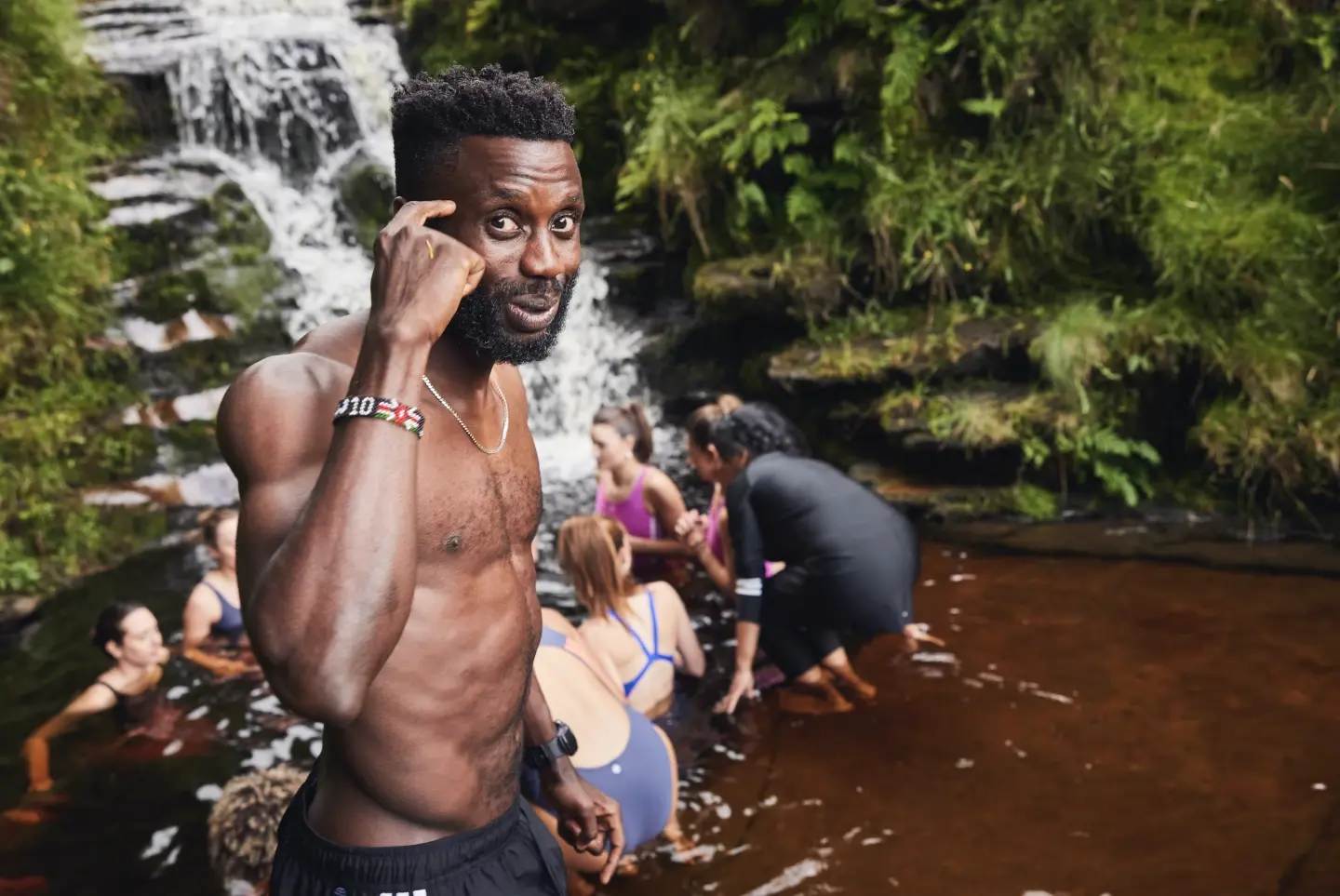 A person standing in a river with people in the background