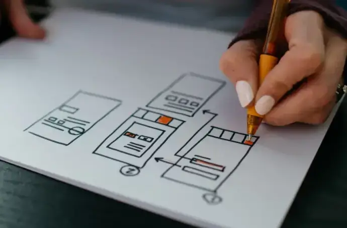 Hand creating a drawing of a wireframe