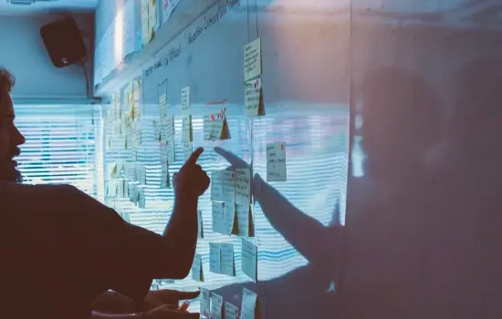 Man points at strategy board with many post-it notes