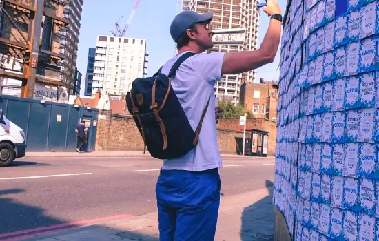 Homme prenant une photo d'un mur d'affichage