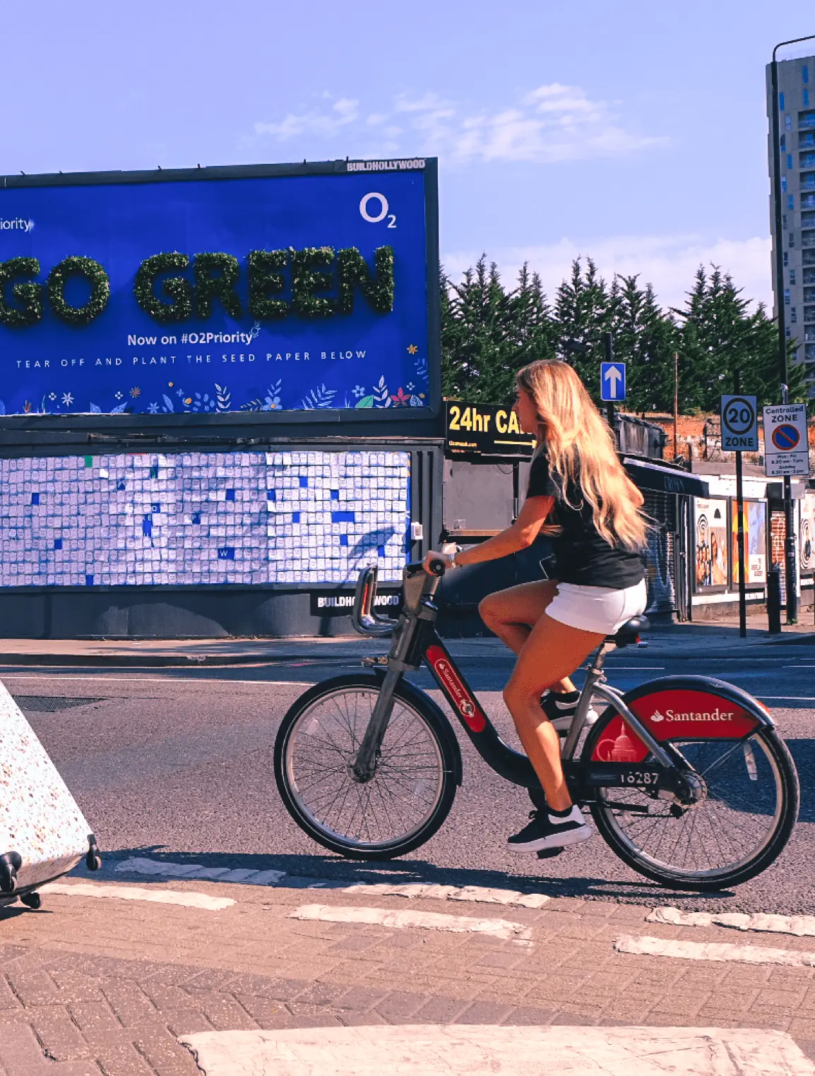 Girl riding a bike past billboard