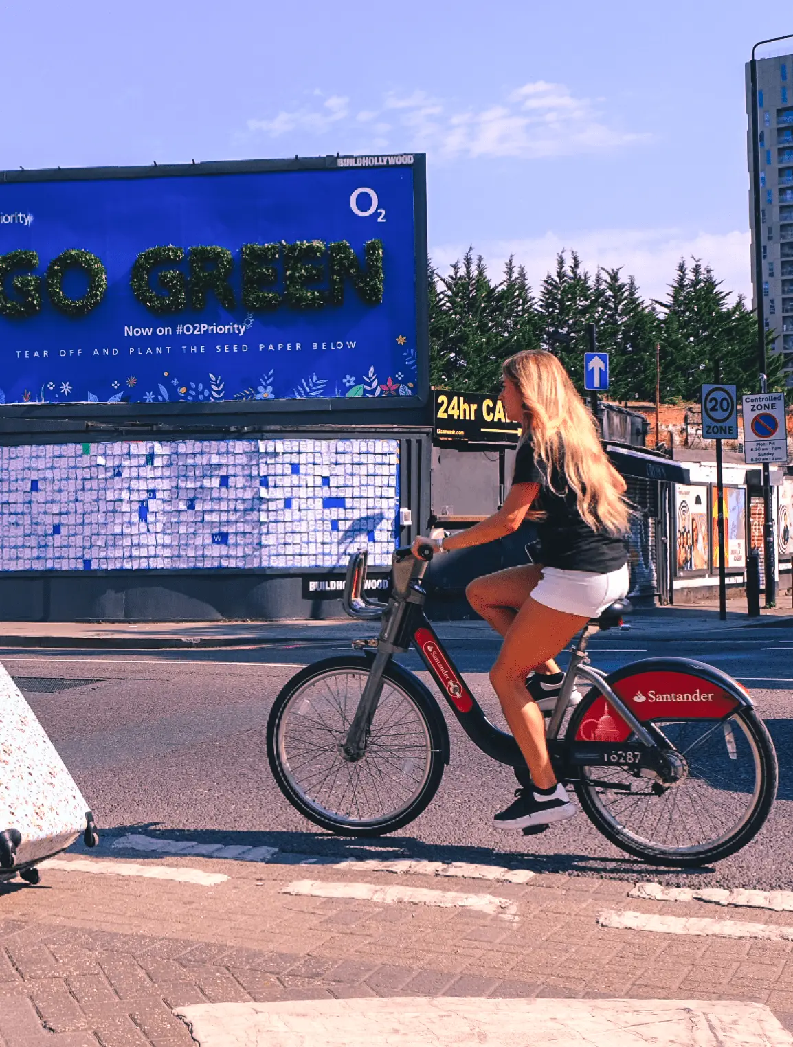 Fille passant à vélo devant un panneau d'affichage
