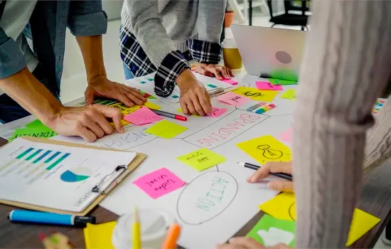 Three people map out a strategy with post-it notes
