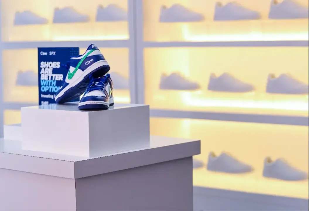 a pair of cboe - custom Nike sneakers on a podium in front of a wall of similar looking white sneakers