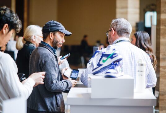 a candid photo of people conversing at a cboe activation with custom cboe-branded Nike sneakers in the foreground