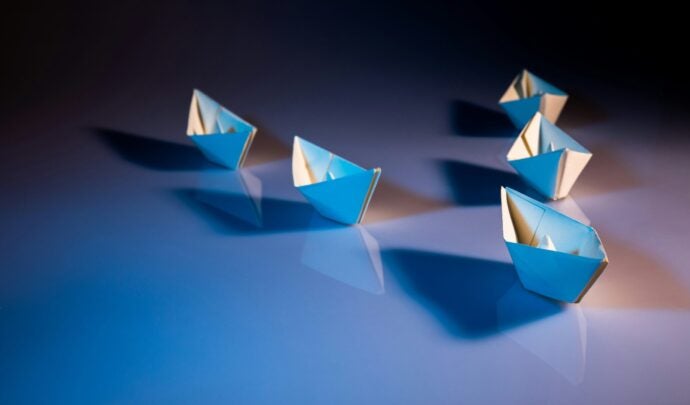 Five paper boats following in sequence