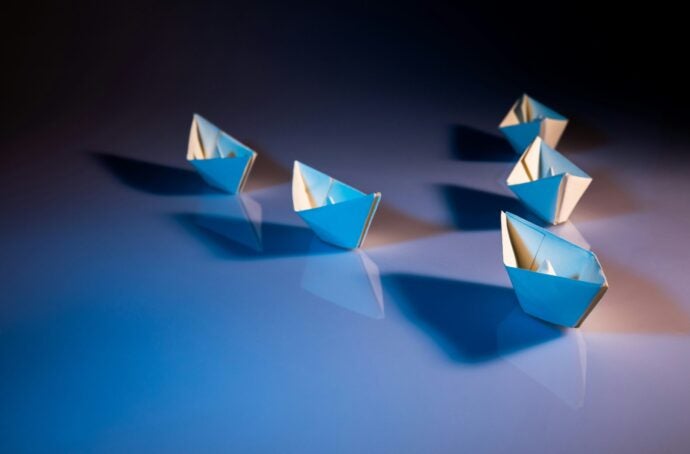 Five paper boats following in sequence