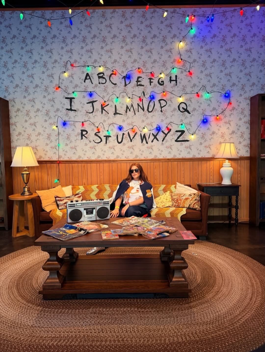person sitting on couch with fairy lights in netflix house