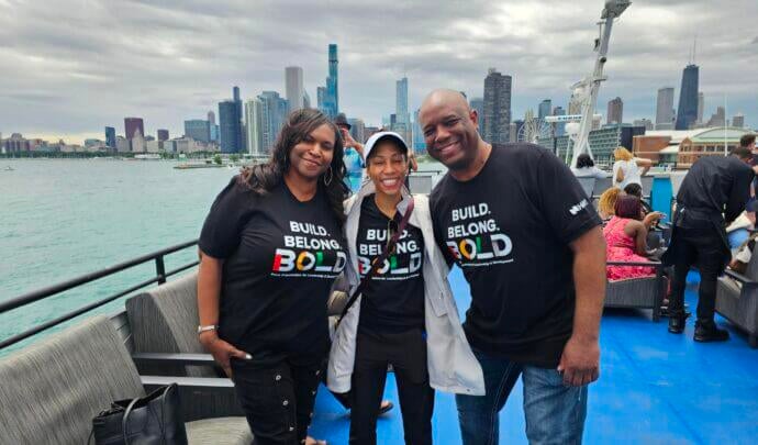 A group of people posing in front of the Chicago skyline on a boat