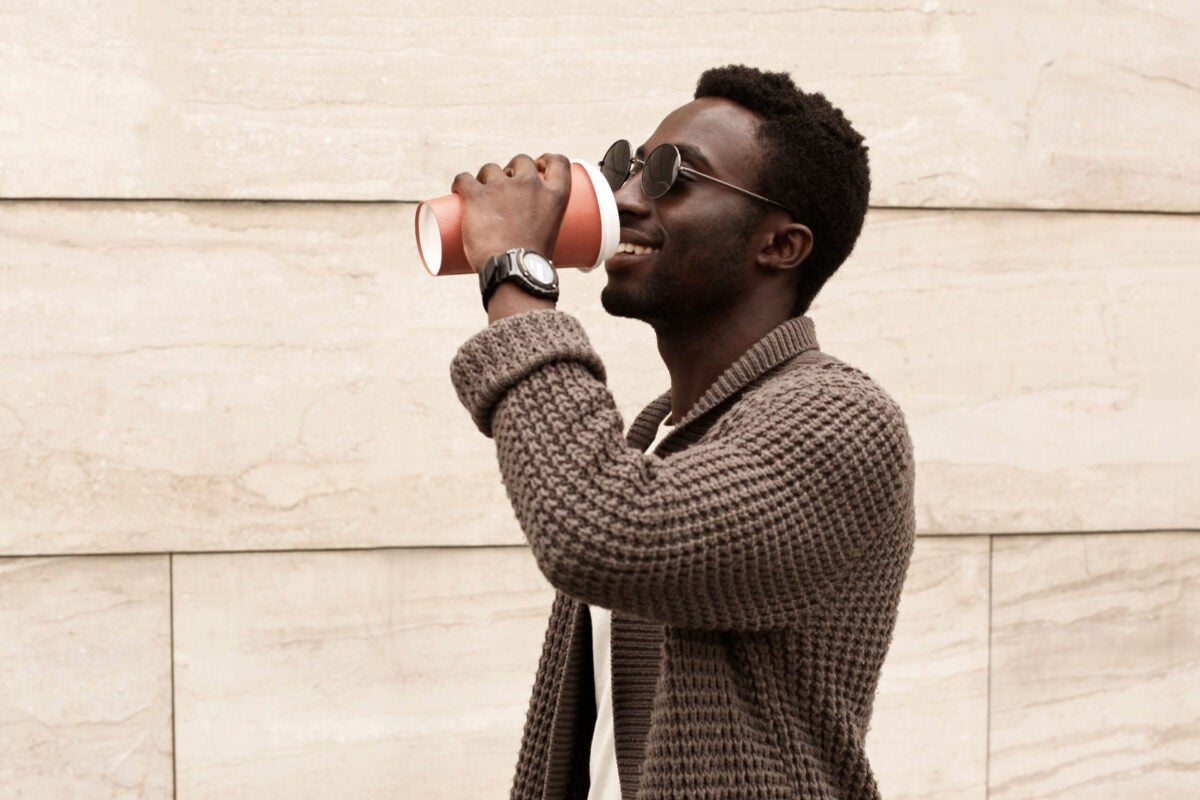 man in sunglasses drinking from takeaway coffee cup