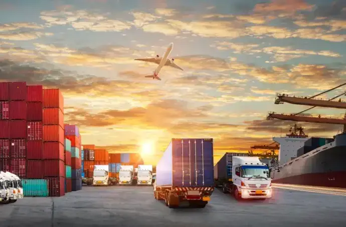 Panorama du quai d’expédition avec de nombreux conteneurs et des camions, un avion et un bateau