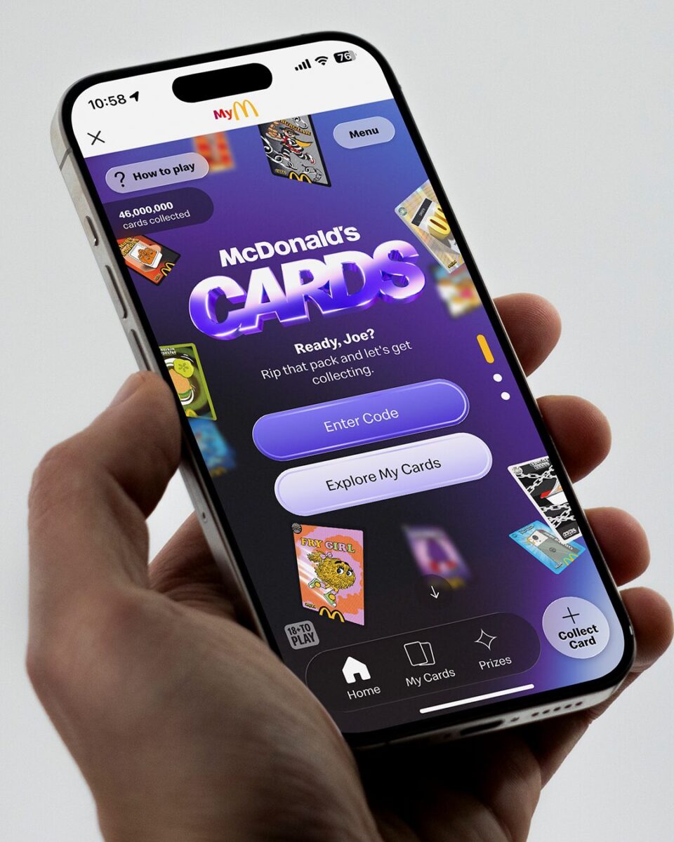 A hand holding a phone with a McDonald's UK Cards digital experience