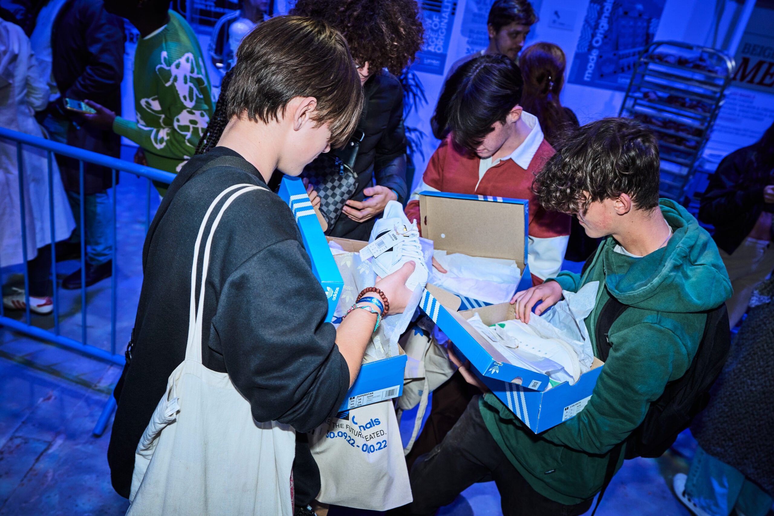 People unboxing adidas shoes