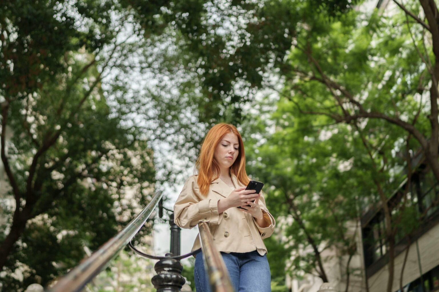 girl on her phone surrounded by trees
